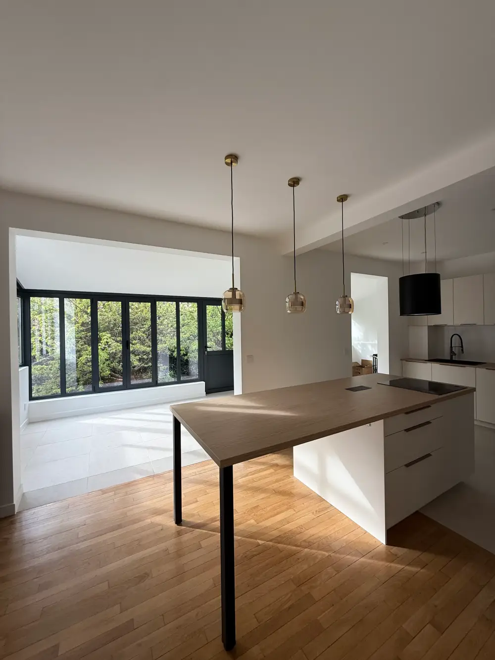Cuisine moderne avec îlot central et verrière intérieure à Clamart