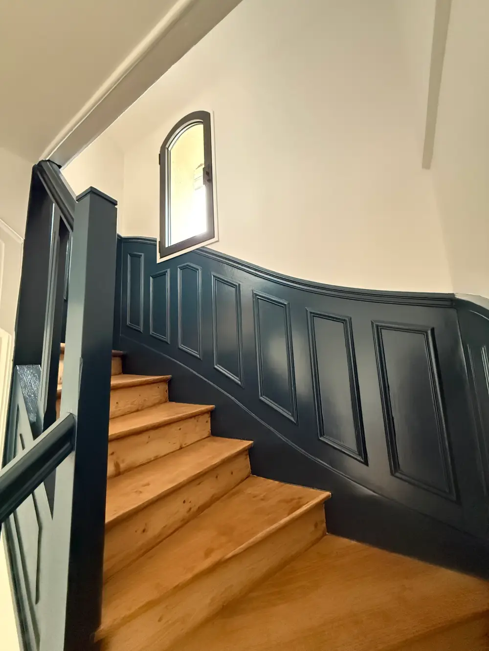Escalier rénové avec boiseries peintes en bleu foncé dans une maison à Clamart