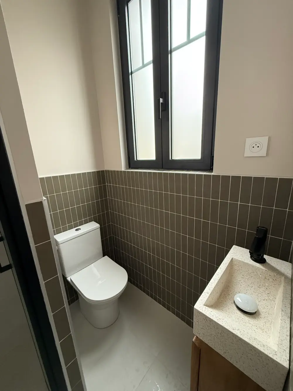 WC rénovés avec carrelage mural taupe et lave-mains dans une maison à Clamart