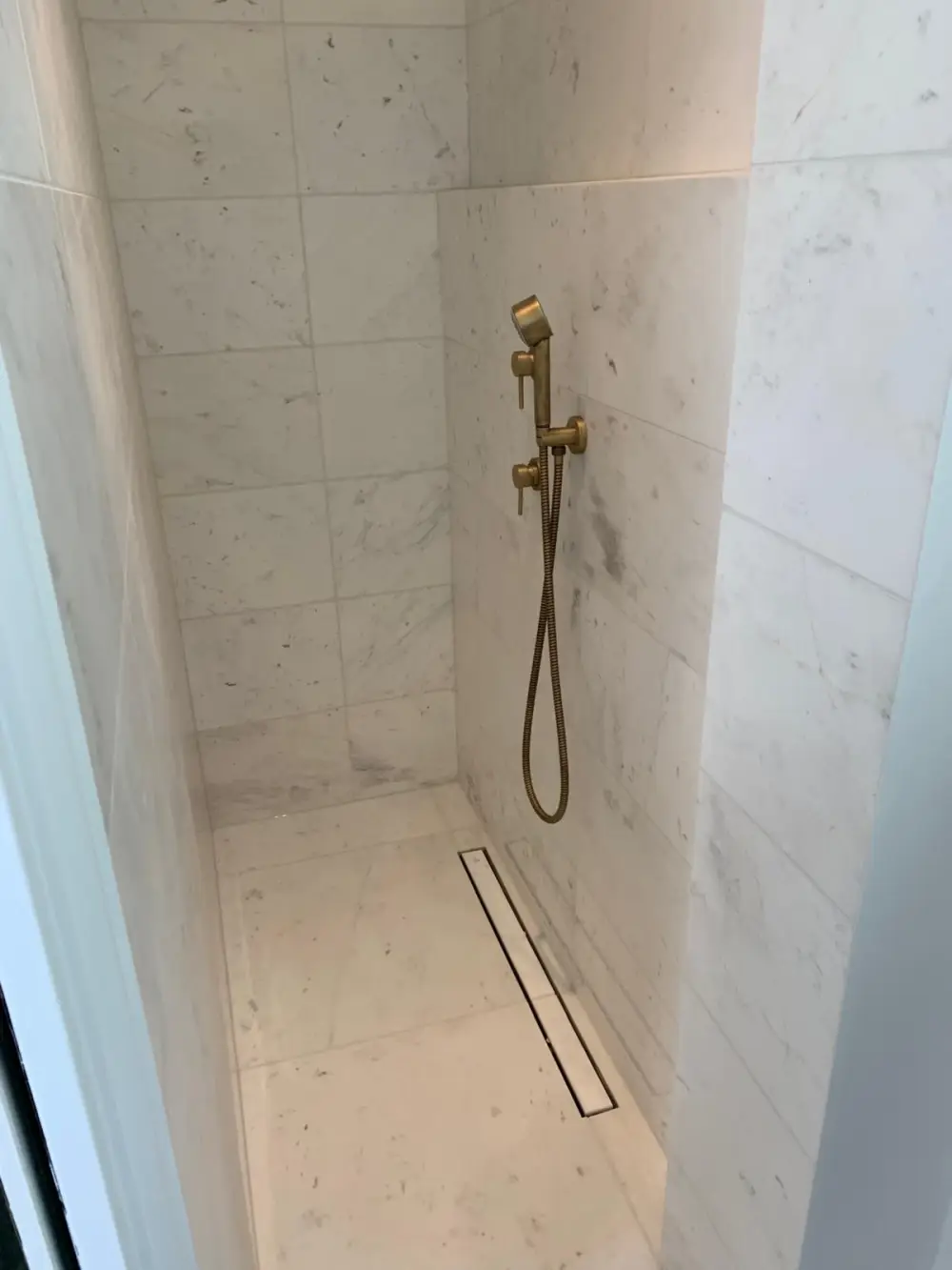 Douche à l’italienne avec caniveau linéaire et carrelage effet marbre en Île-de-France