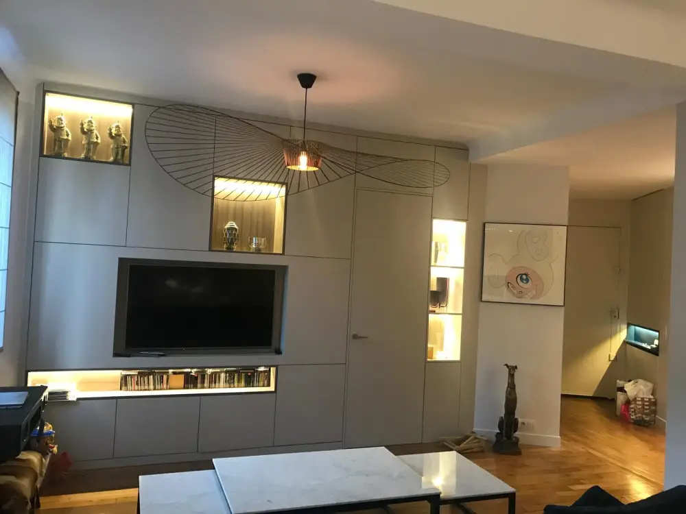 Meuble TV sur mesure avec niches lumineuses dans un salon rénové en Île-de-France