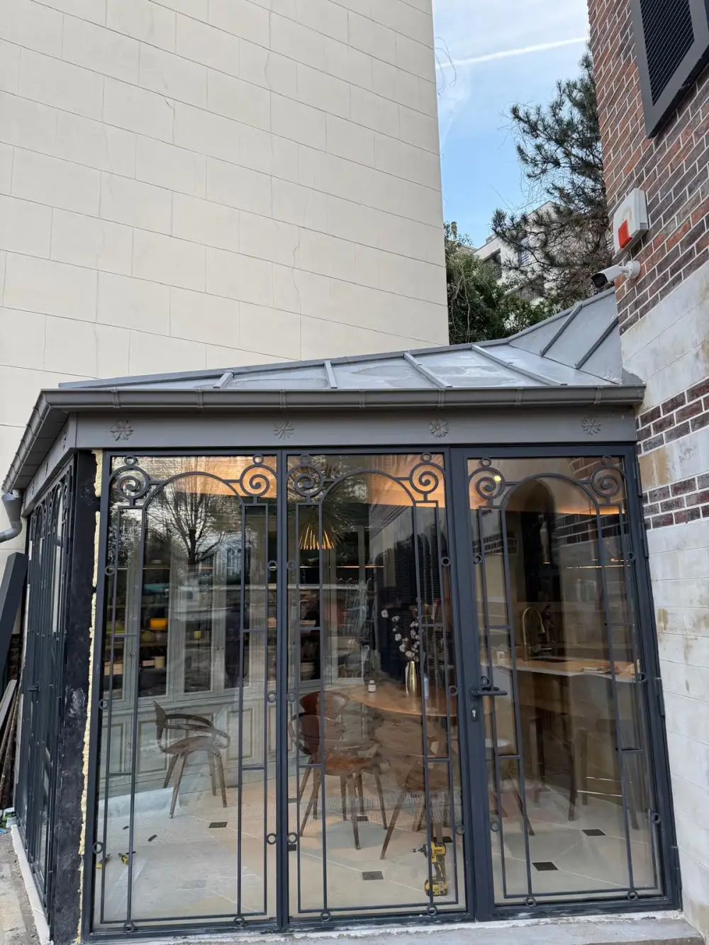 Verrière extérieure rénovée avec structure métallique et éclairage intérieur en Île-de-France