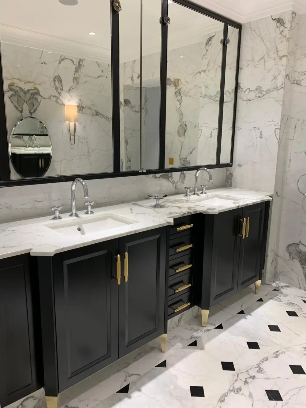 Meuble double vasque en marbre avec robinetterie chromée et poignées dorées