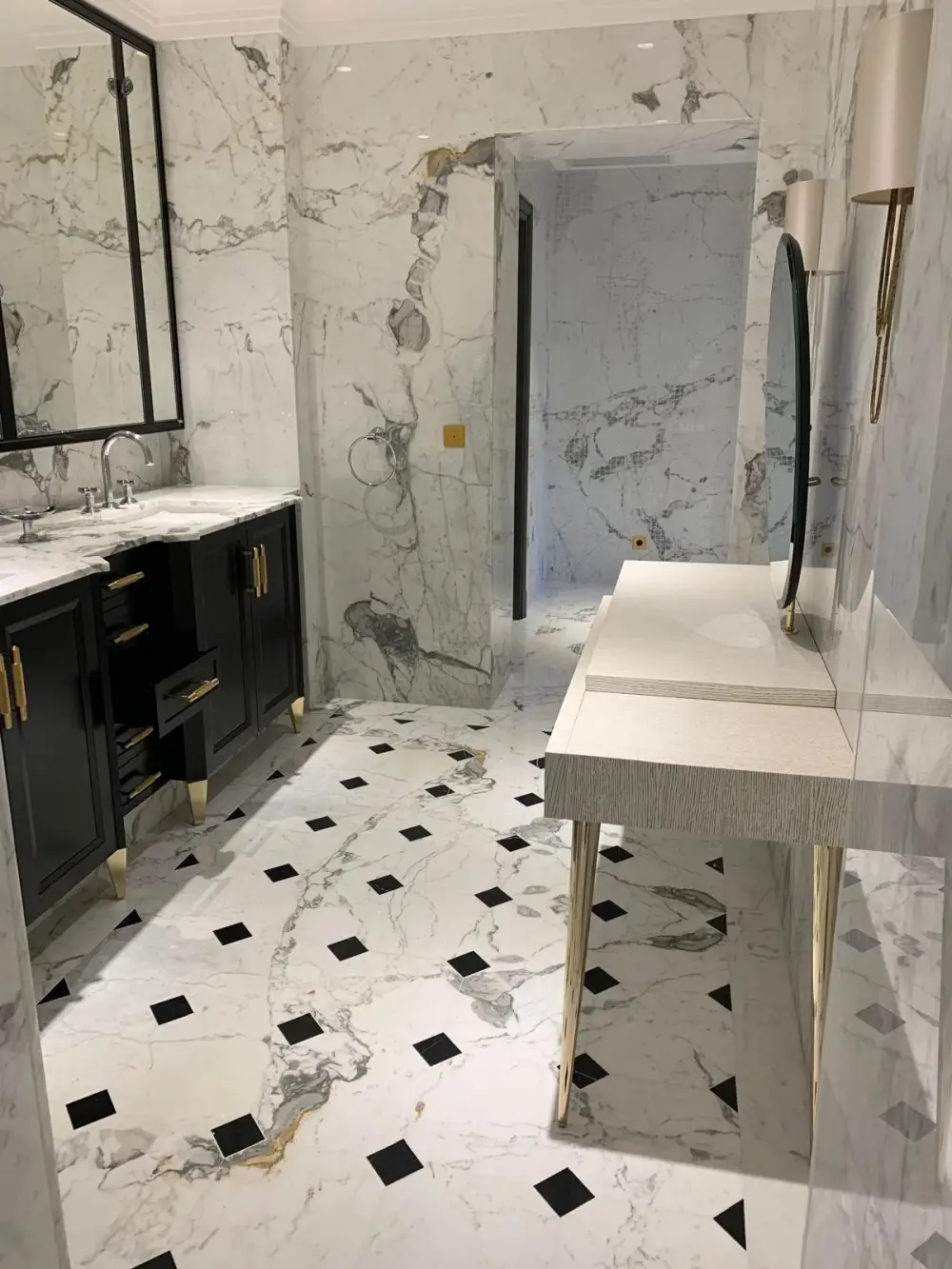 Meuble double vasque noir avec plan en marbre dans une salle de bain rénovée