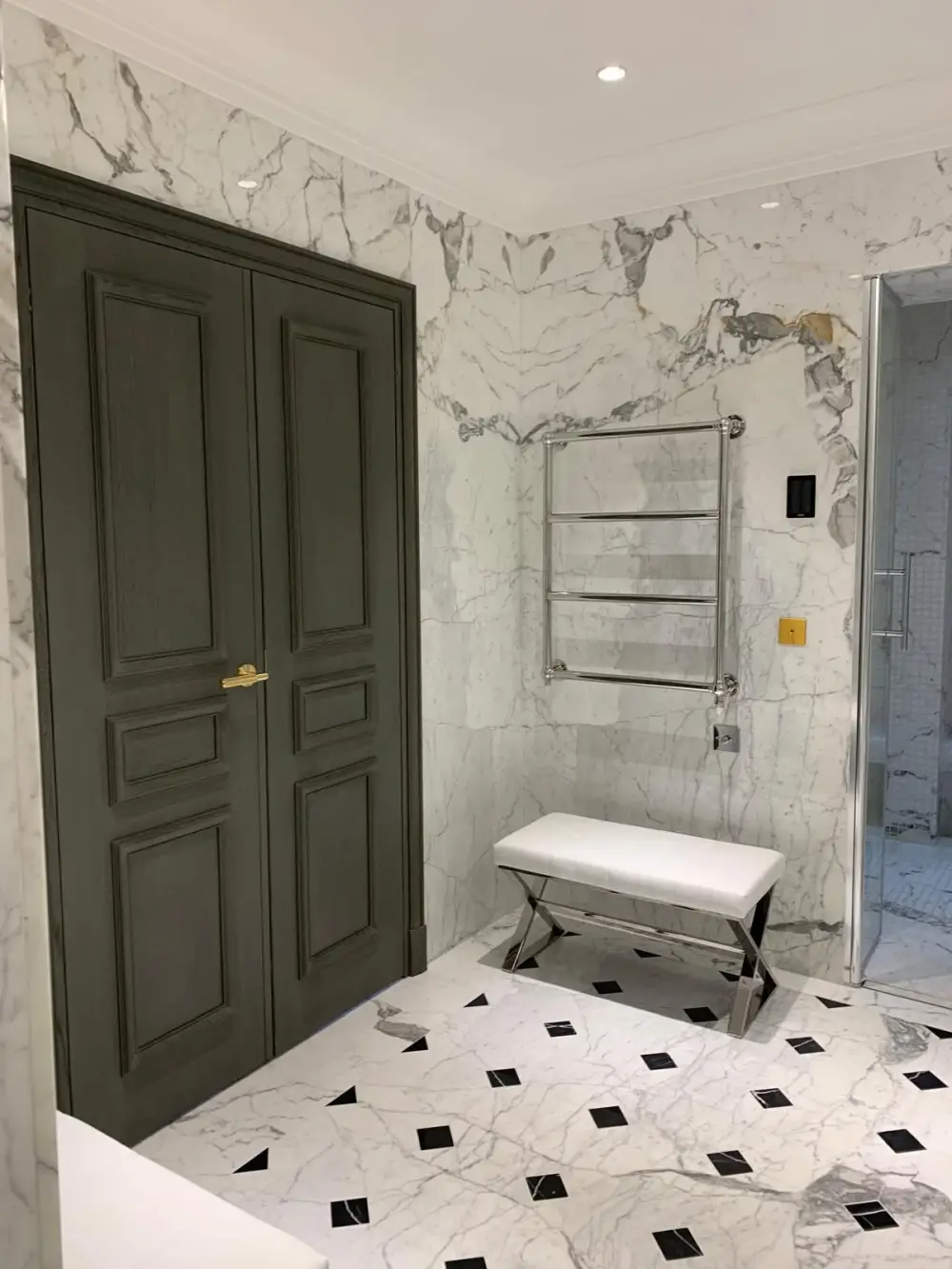 Salle de bain en marbre avec porte moulurée et radiateur sèche-serviettes