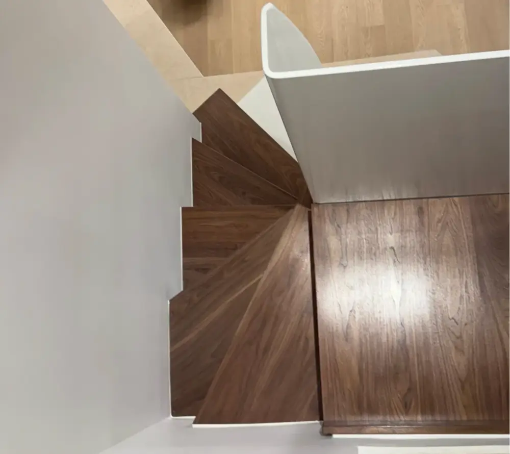Escalier en bois rénové avec garde-corps blanc dans un appartement